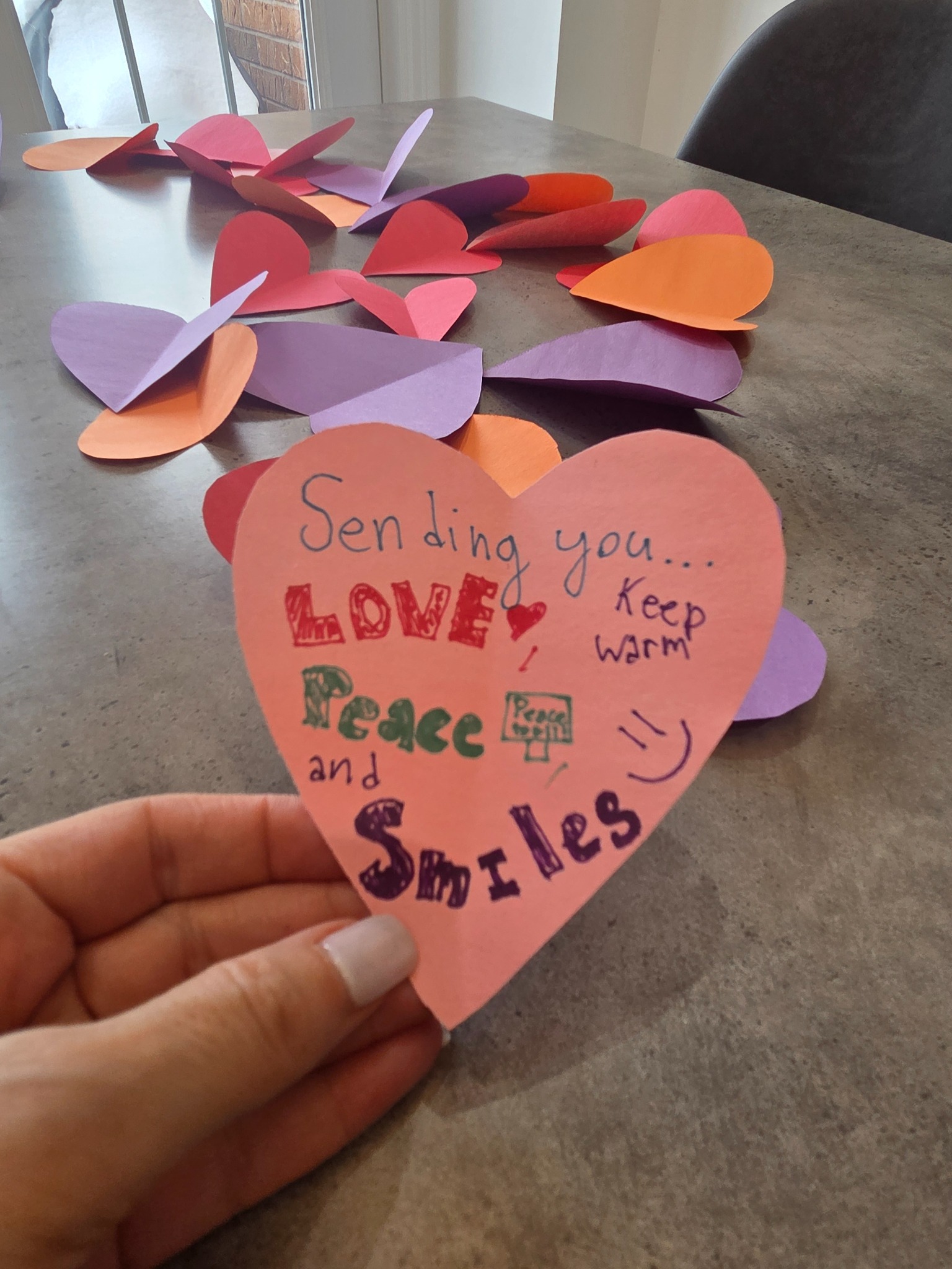 Colourful handmade heart-shaped Hope Notes with messages of love, peace and warmth