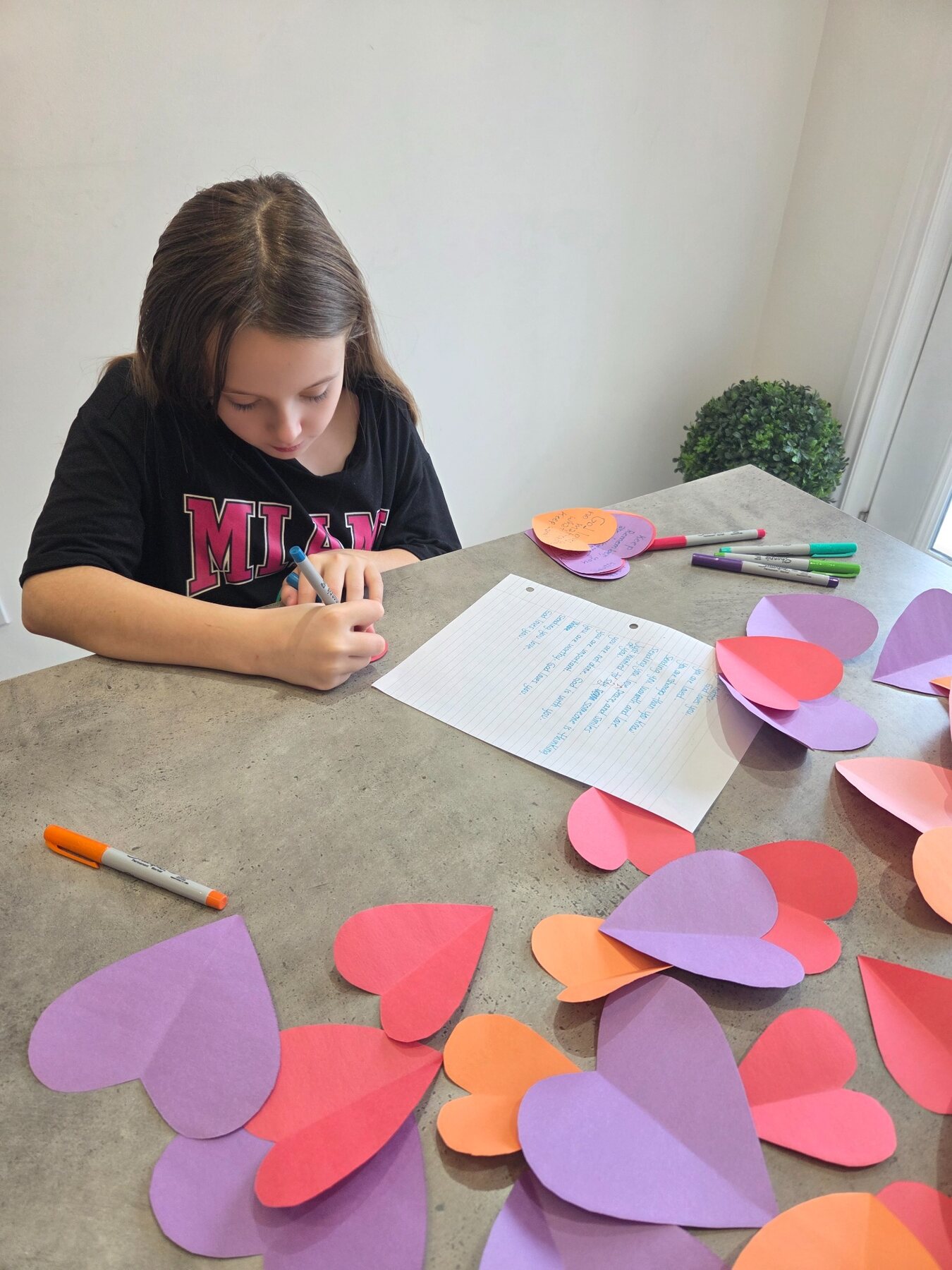 A child writing colourful Hope Notes