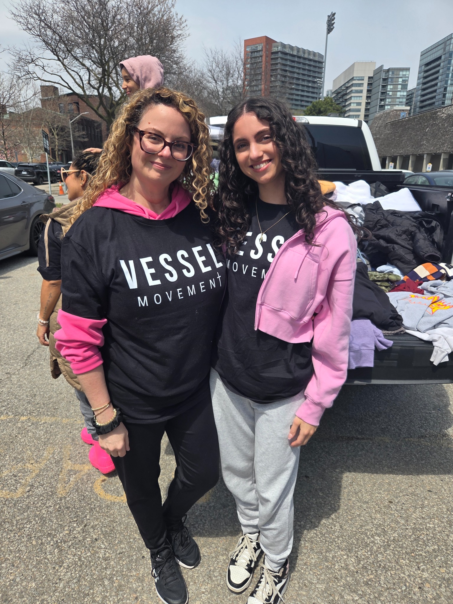 Two women wearing Vessel Movement T-shirts during community outreach