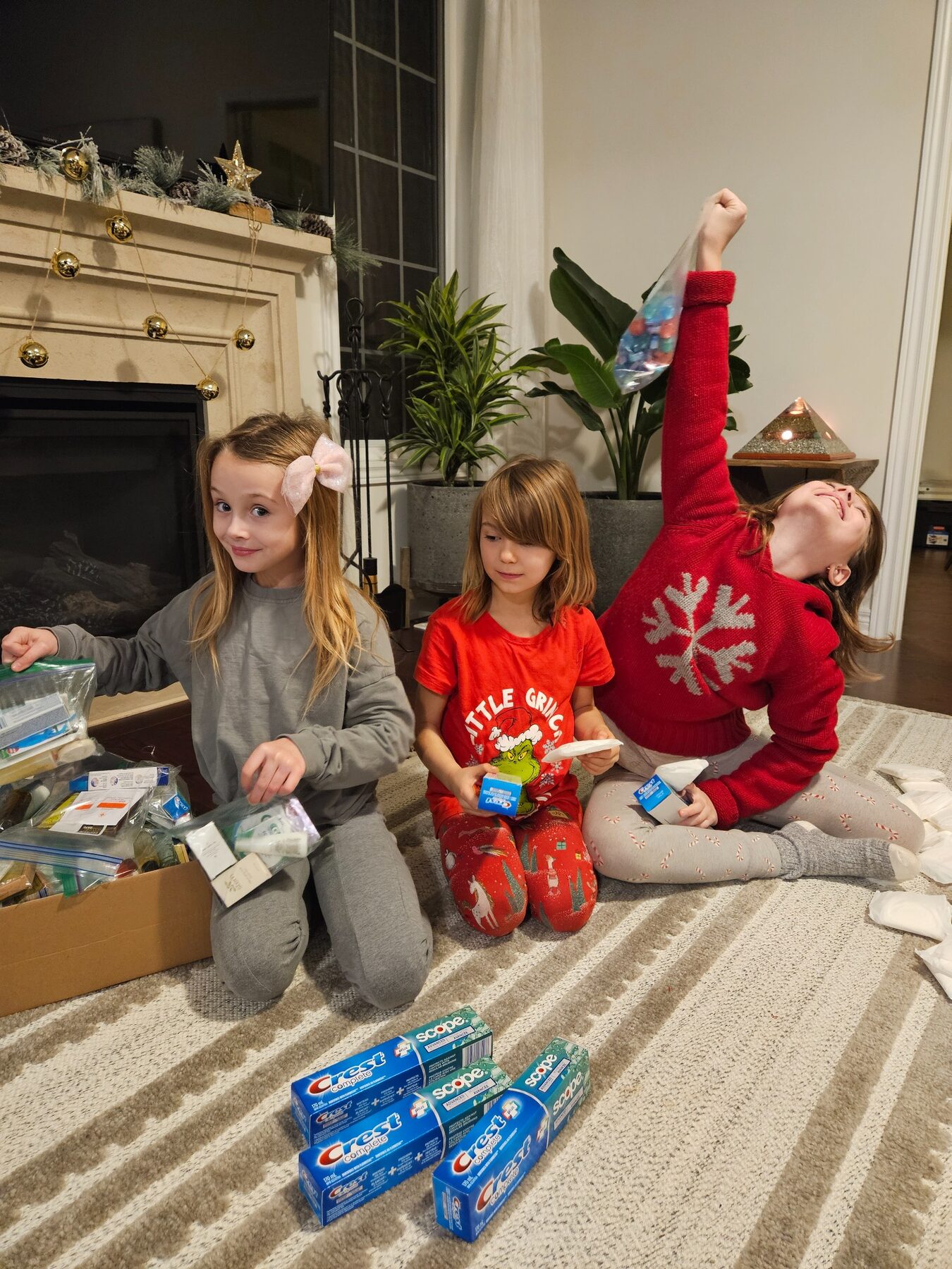 Three children assembling care packages at home